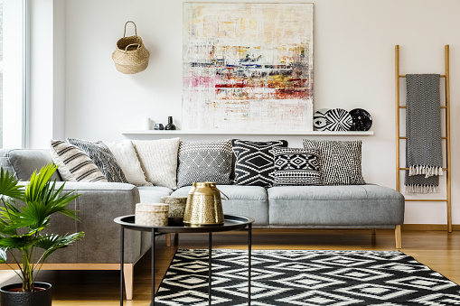 magen de living con sillon color gris con almohadones estampados negros,grises y blancos